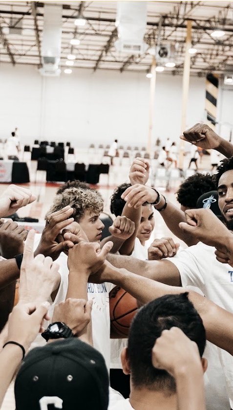 Athletes huddled together, fists raised, before a showcase session